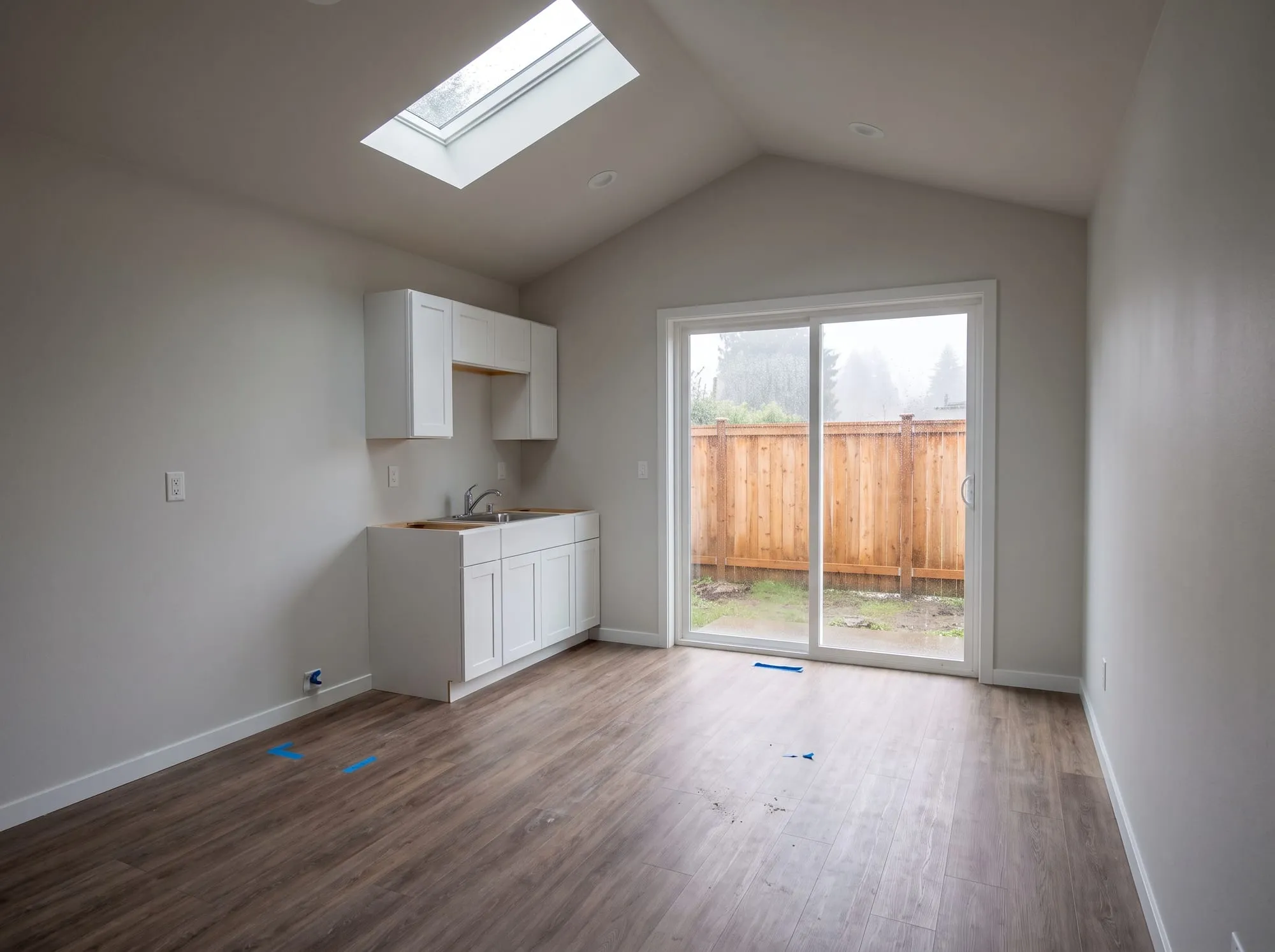 Small ADU studio interior with smooth walls, vaulted ceiling and skylight