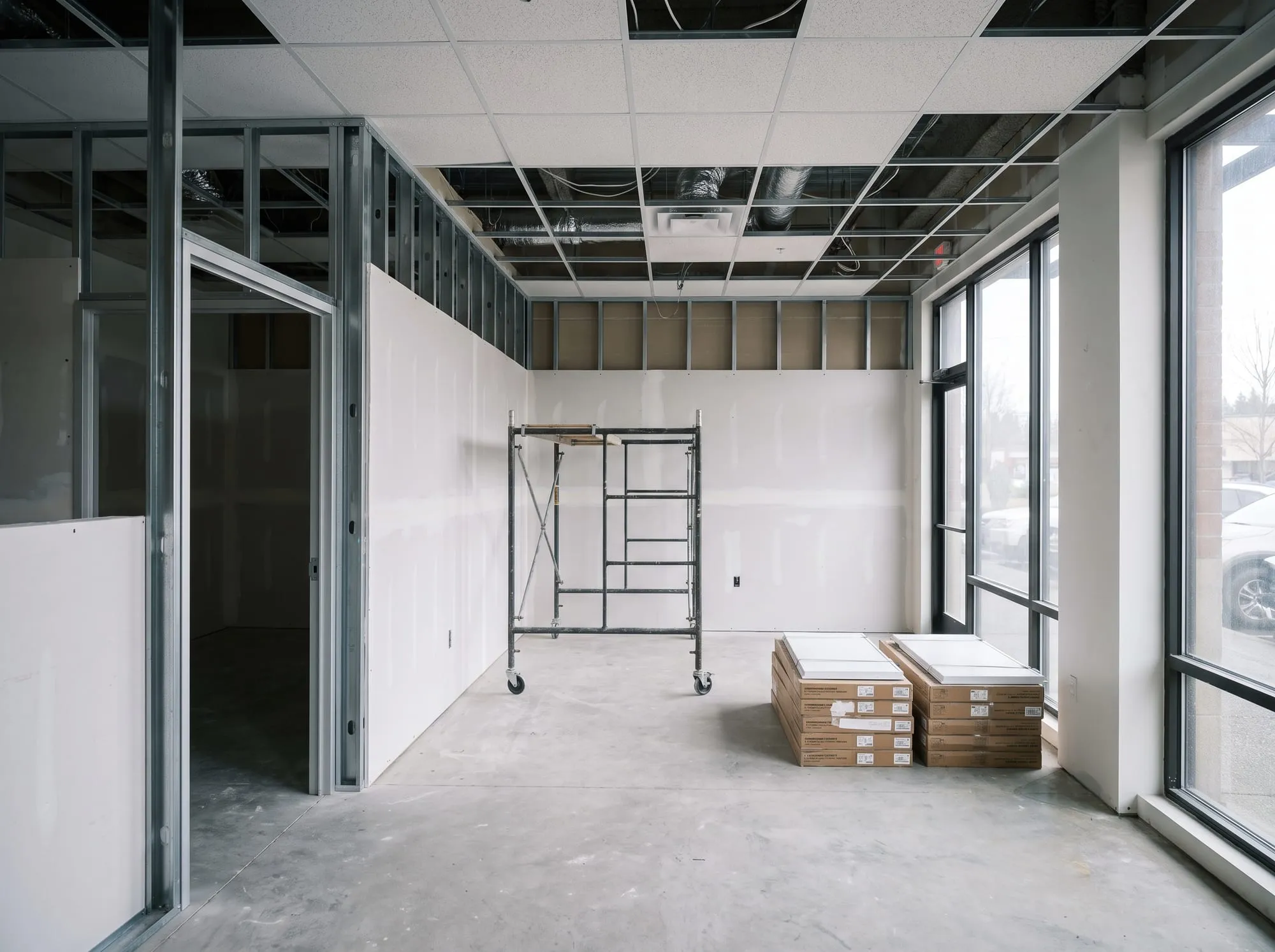 Commercial office build-out with new metal-stud drywall partitions and ceiling grid